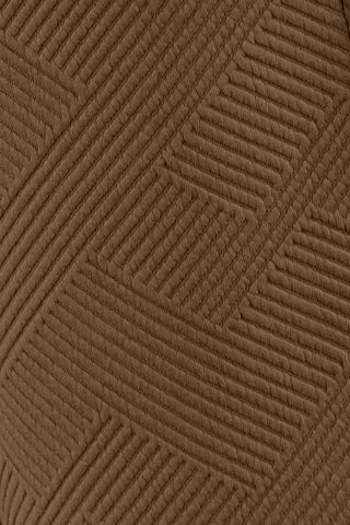Close-up of brown textured fabric with geometric pattern from a long sleeve top and drawstring shorts set.