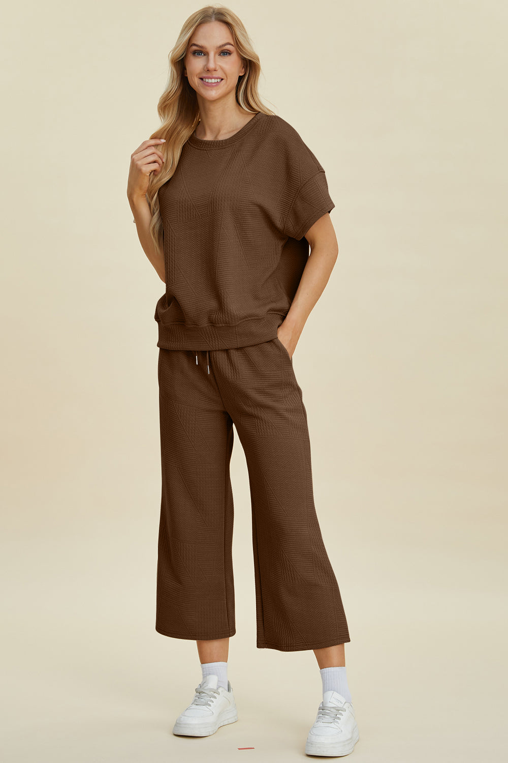 Woman wearing brown texture round neck top and pants set with drawstring, slightly stretchy, two-piece outfit, casual style.