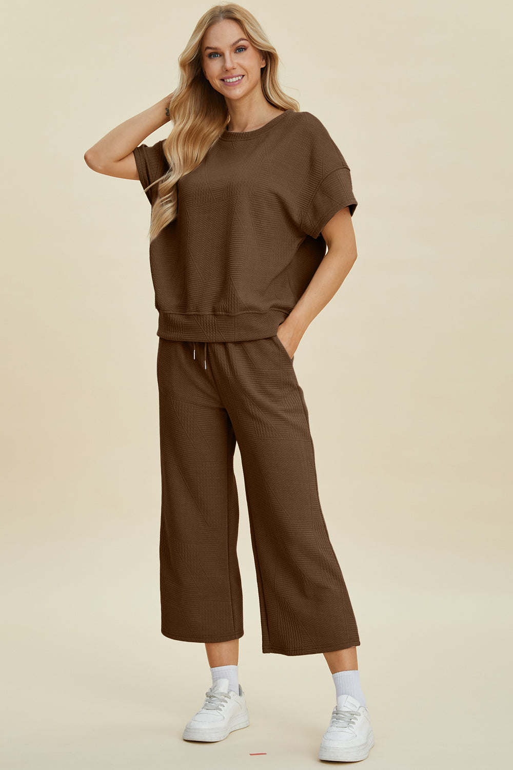 Woman wearing a brown texture round neck top and pants set with a drawstring, slightly stretchy fabric, two-piece casual outfit.