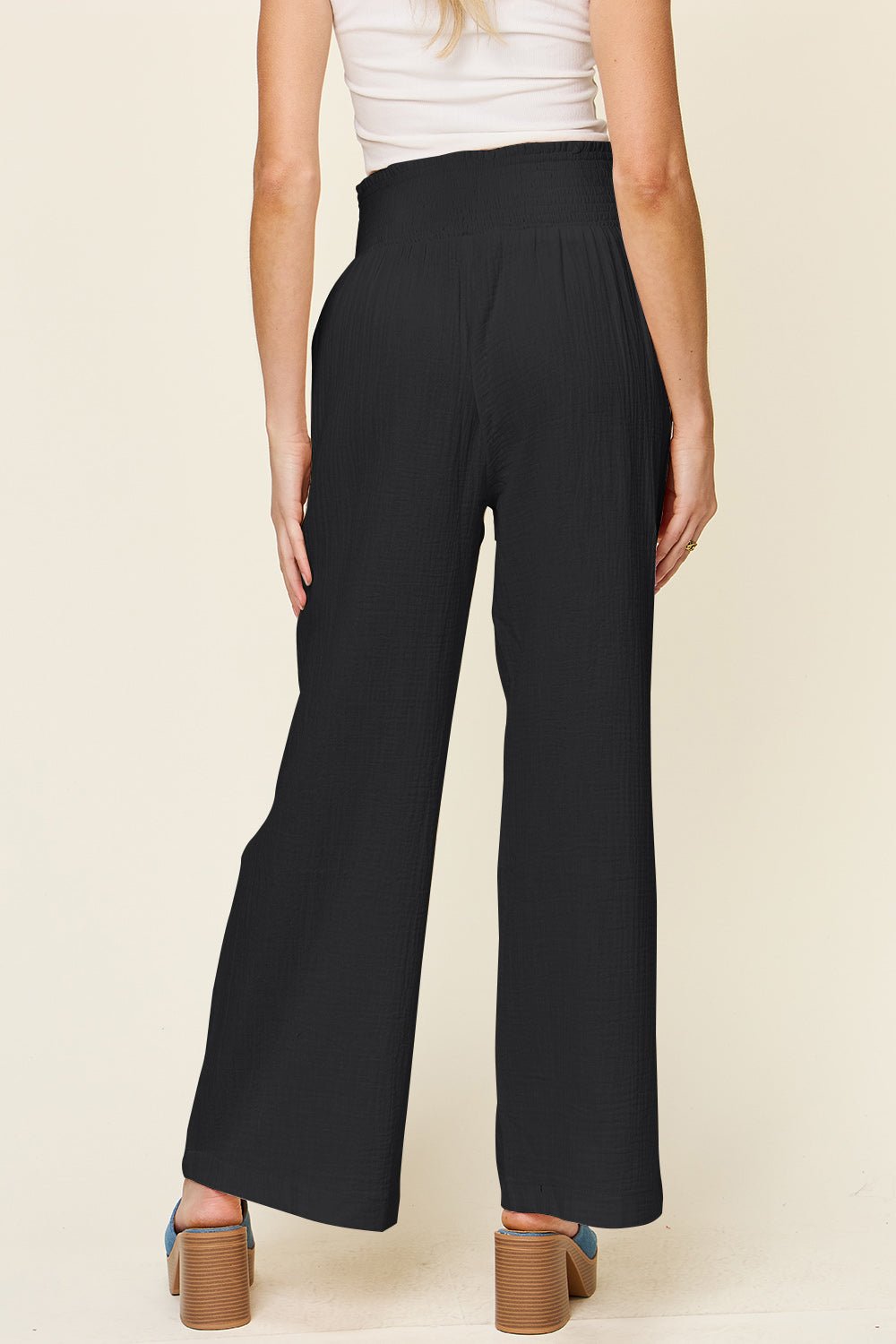 Smocked waist wide leg pants in black, featuring an opaque 100% cotton fabric for a comfortable and stylish look.