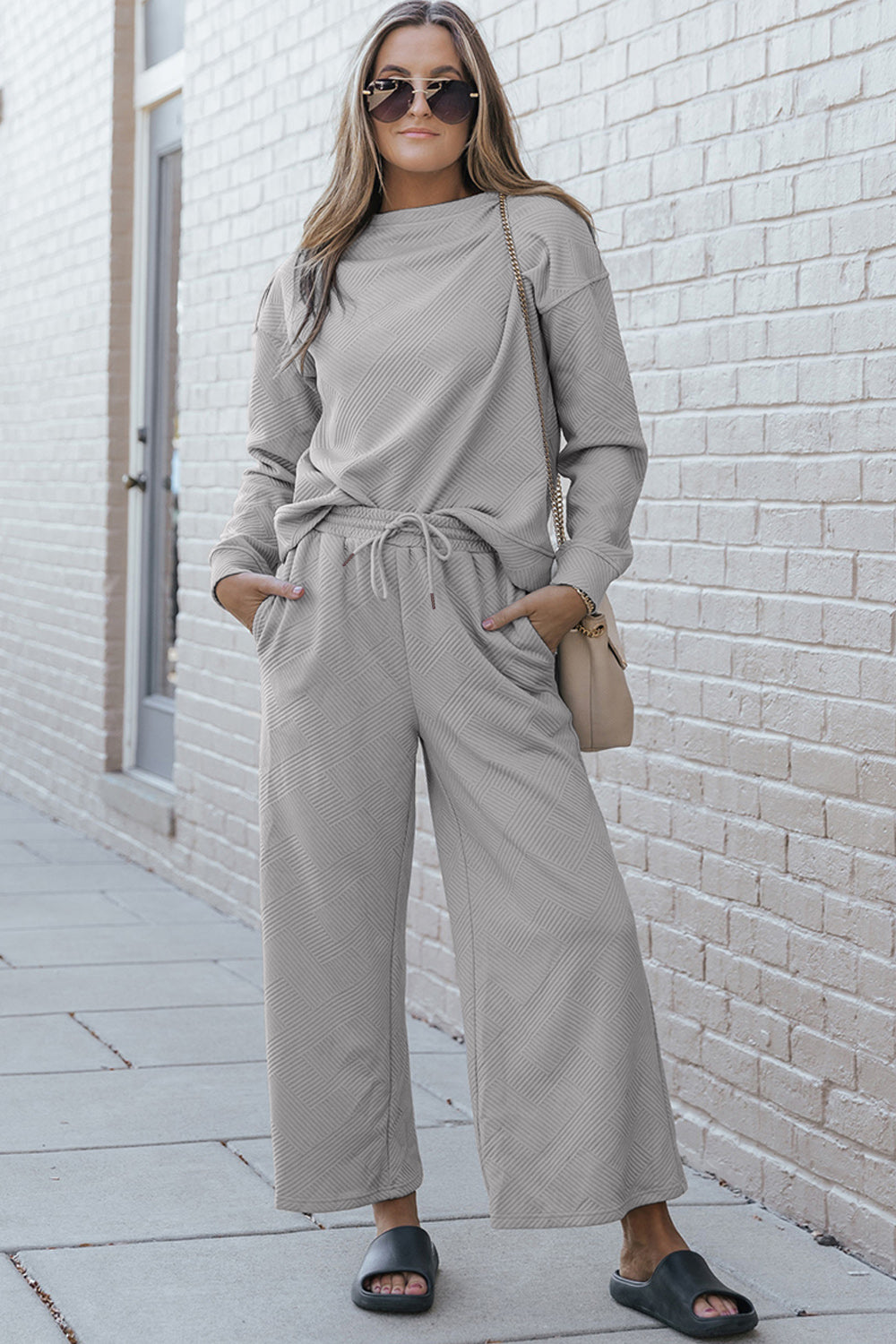 Woman wearing textured long sleeve top and drawstring pants set, casual chic outfit with slightly stretchy fabric, street style look.