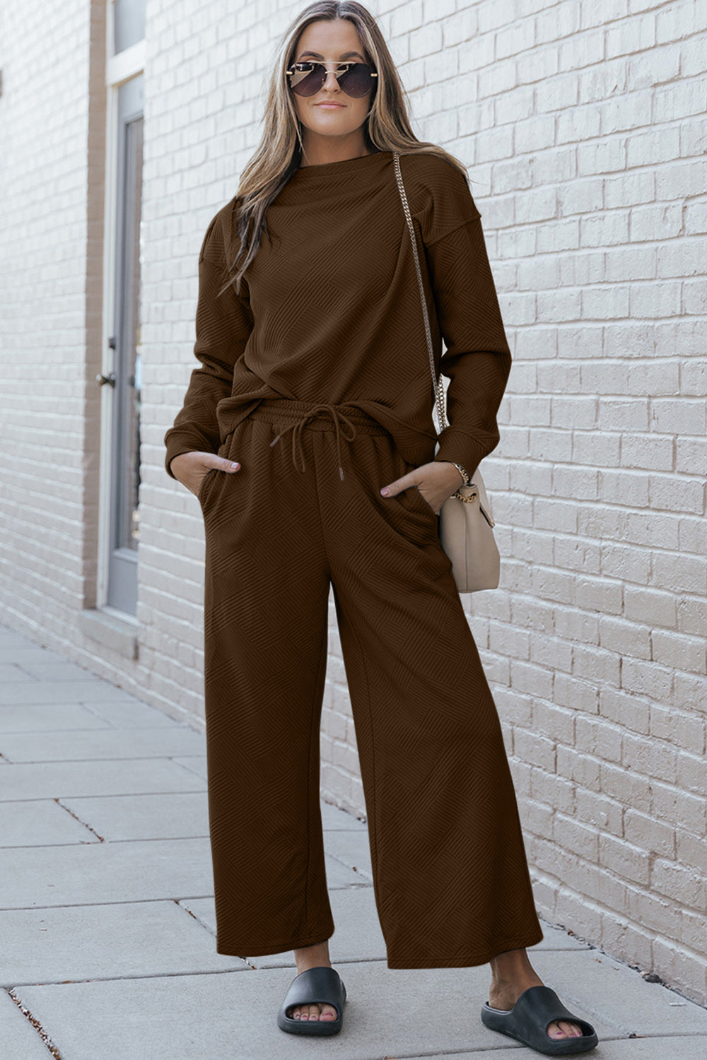 Woman wearing a textured long sleeve top and drawstring pants set in brown, stylish casual wear with a relaxed fit.