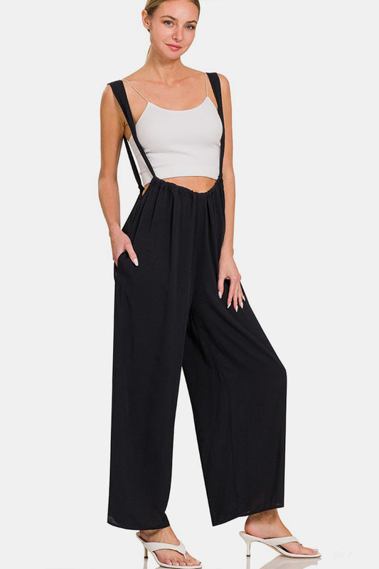 Stylish tie-back suspender jumpsuit with pockets and retro suspender straps in black, perfect for versatile day-to-night styling.