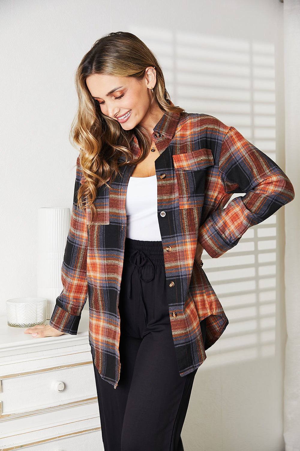 Woman wearing a plaid dropped shoulder shirt, combining effortless elegance and versatile style, ideal for casual and dressy looks.