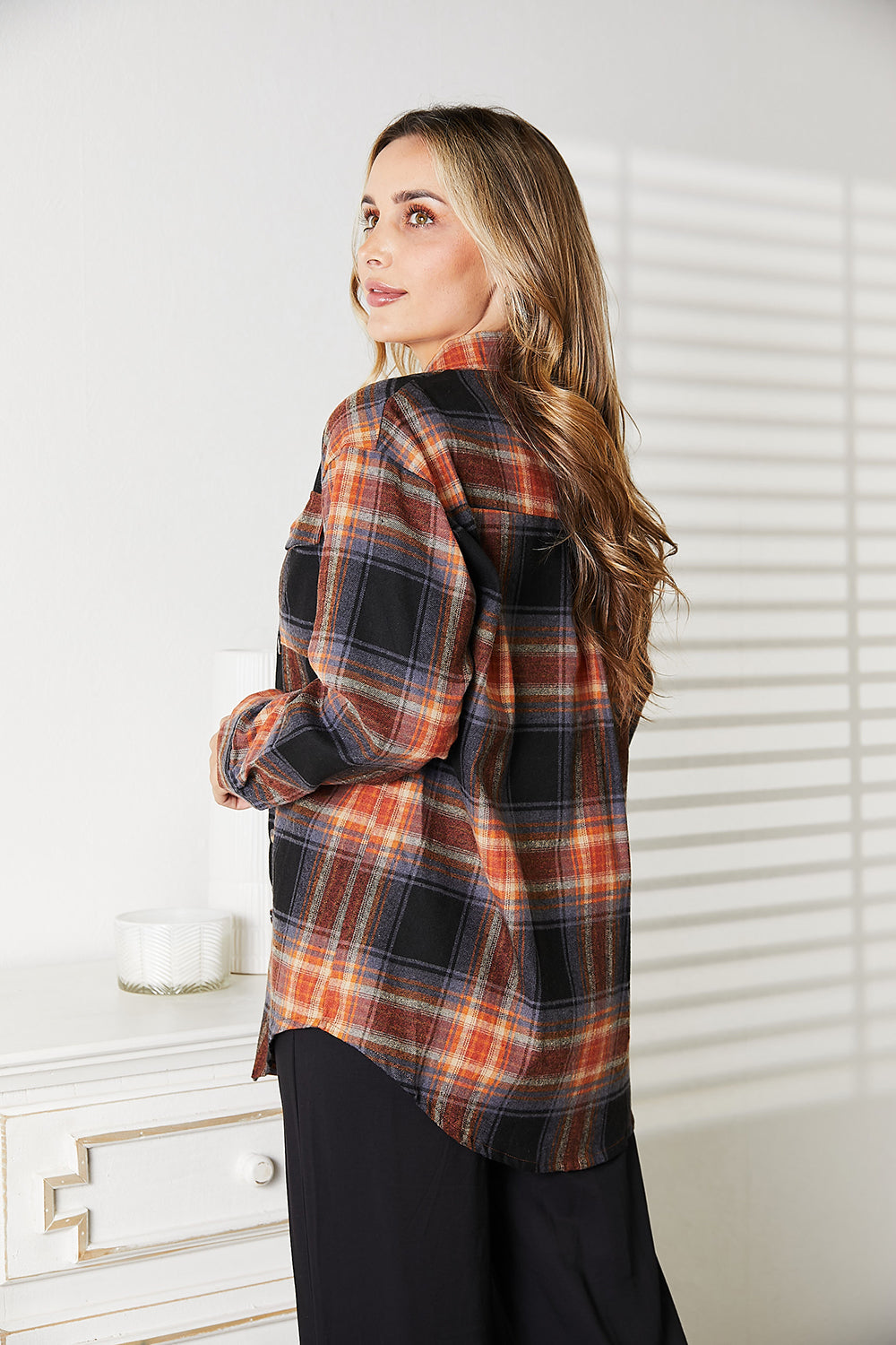 Woman wearing plaid dropped shoulder shirt with sleek fit, styled casually, emphasizing effortless elegance and versatility.