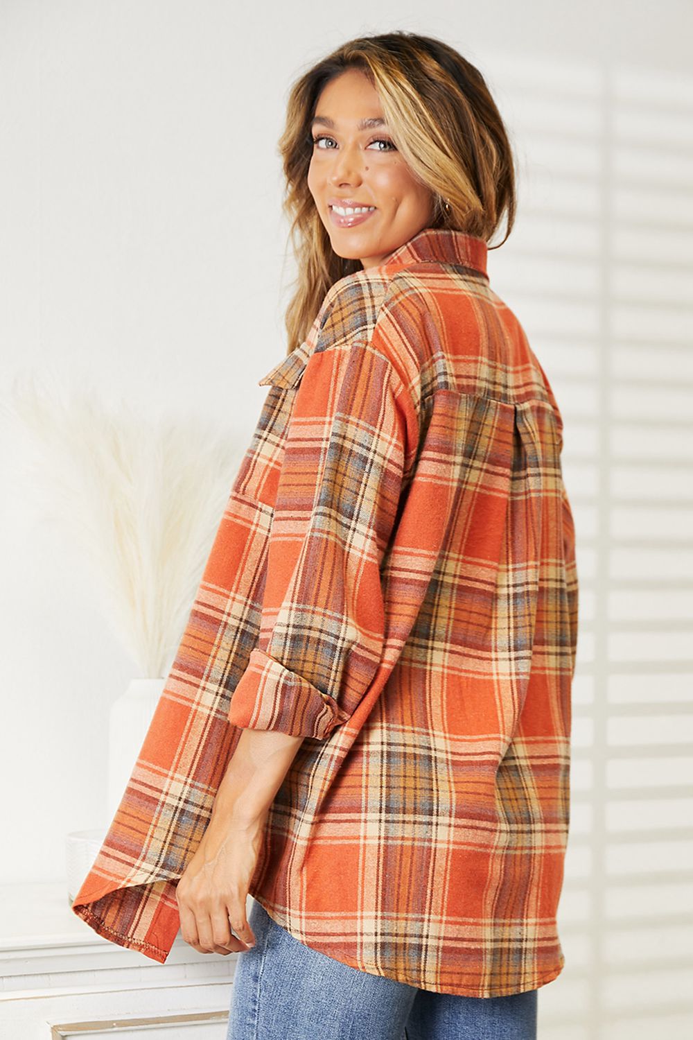 Woman wearing plaid dropped shoulder shirt with a relaxed fit, perfect for casual or dressy outfits, featuring durable polyester fabric.