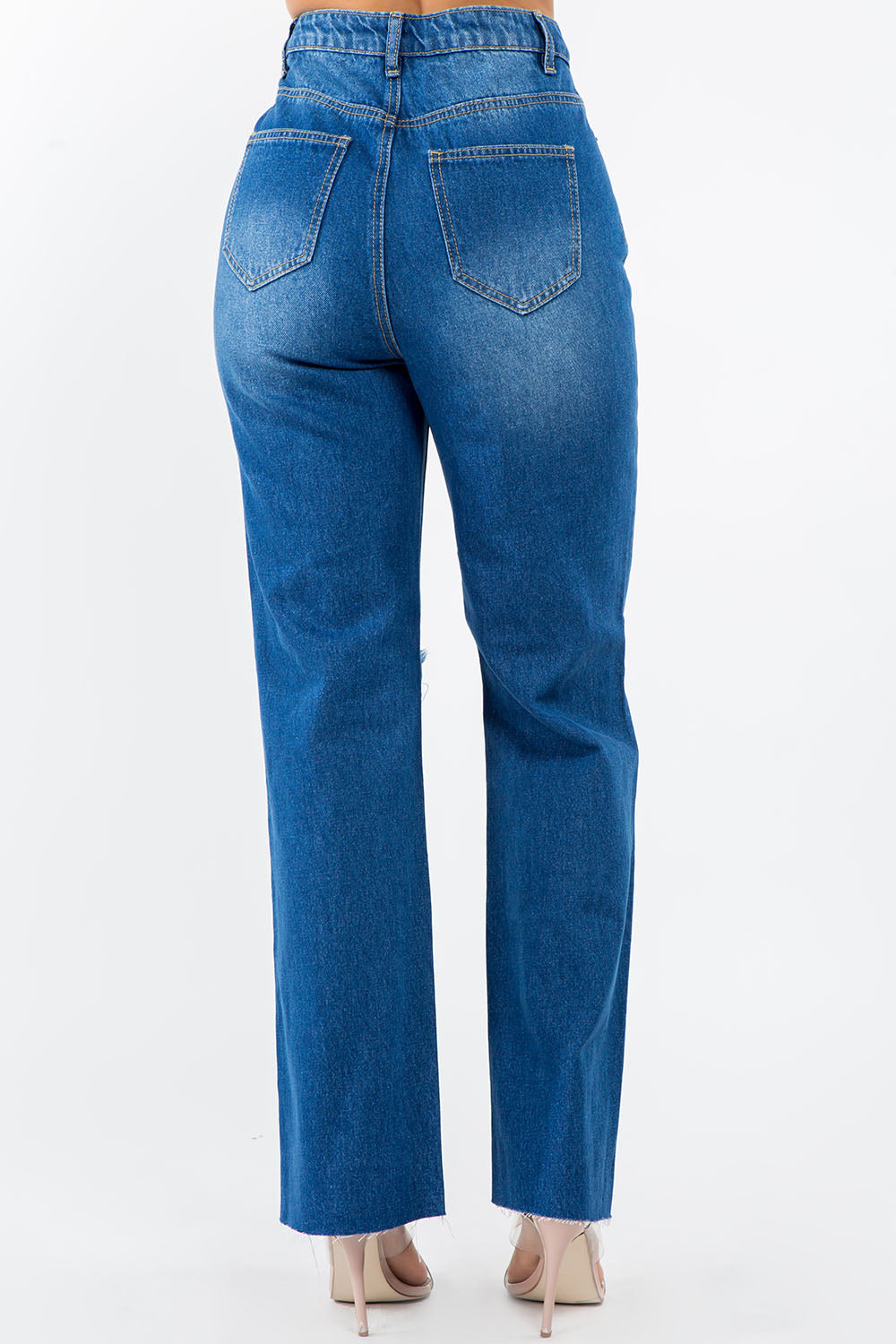 Back view of high waist distressed wide leg jeans with a versatile wash and raw hem, crafted from 100% cotton denim.