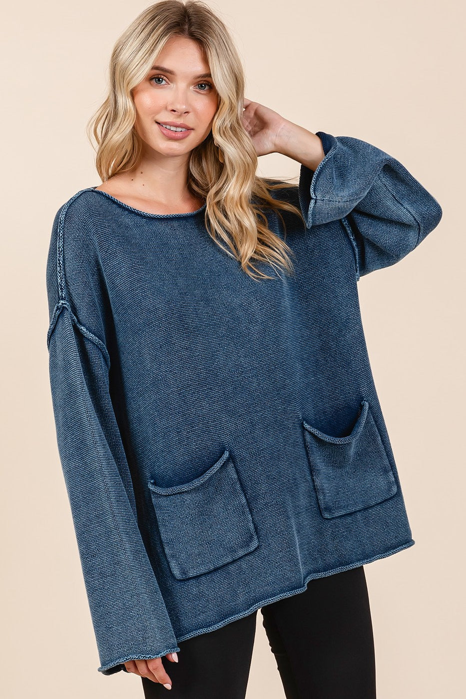 Woman wearing Mittoshop mineral wash patch pocket cut edge sweater in blue, featuring exposed seams and trendy design.