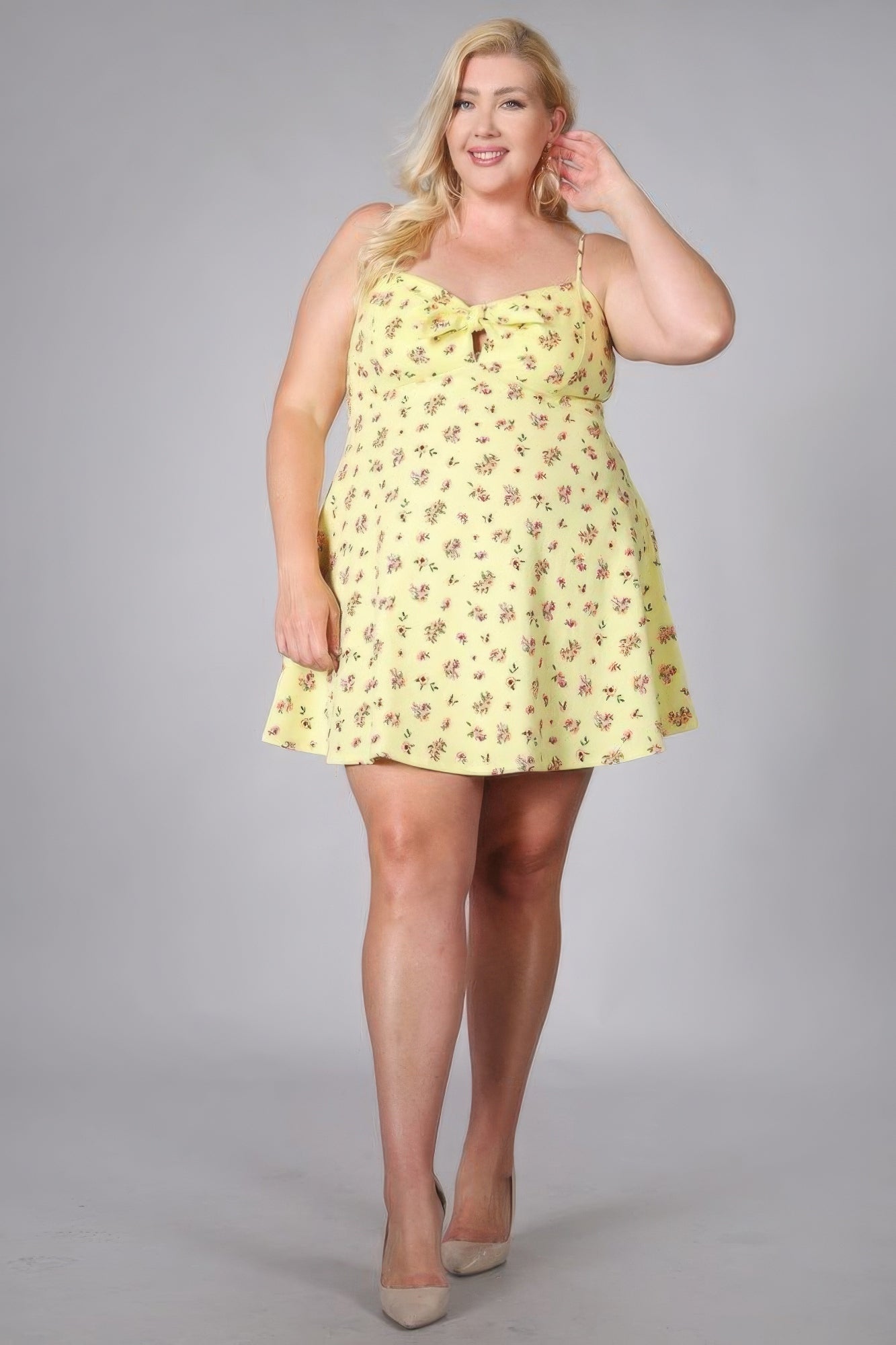 Plus size woman wearing yellow floral print fit and flare mini dress, showcasing trendy and elegant summer fashion.