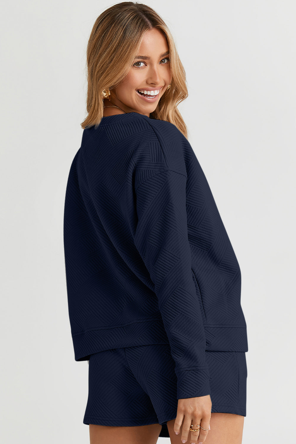 Woman wearing navy Texture Long Sleeve Top and Drawstring Shorts Set, featuring pockets and slightly stretchy fabric.