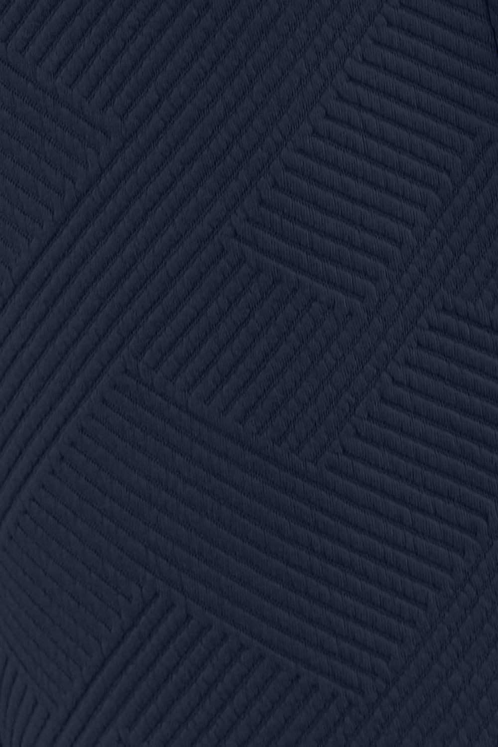 Close-up of navy textured pattern fabric detail from a long sleeve top and drawstring shorts set made of polyester and spandex.