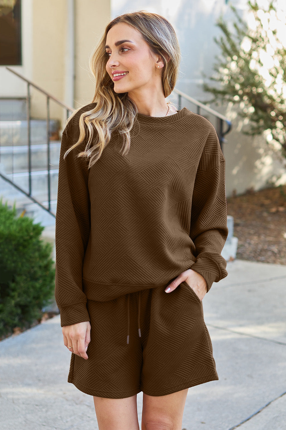 Woman wearing brown texture long sleeve top and drawstring shorts set with pockets, made of polyester and spandex blend.