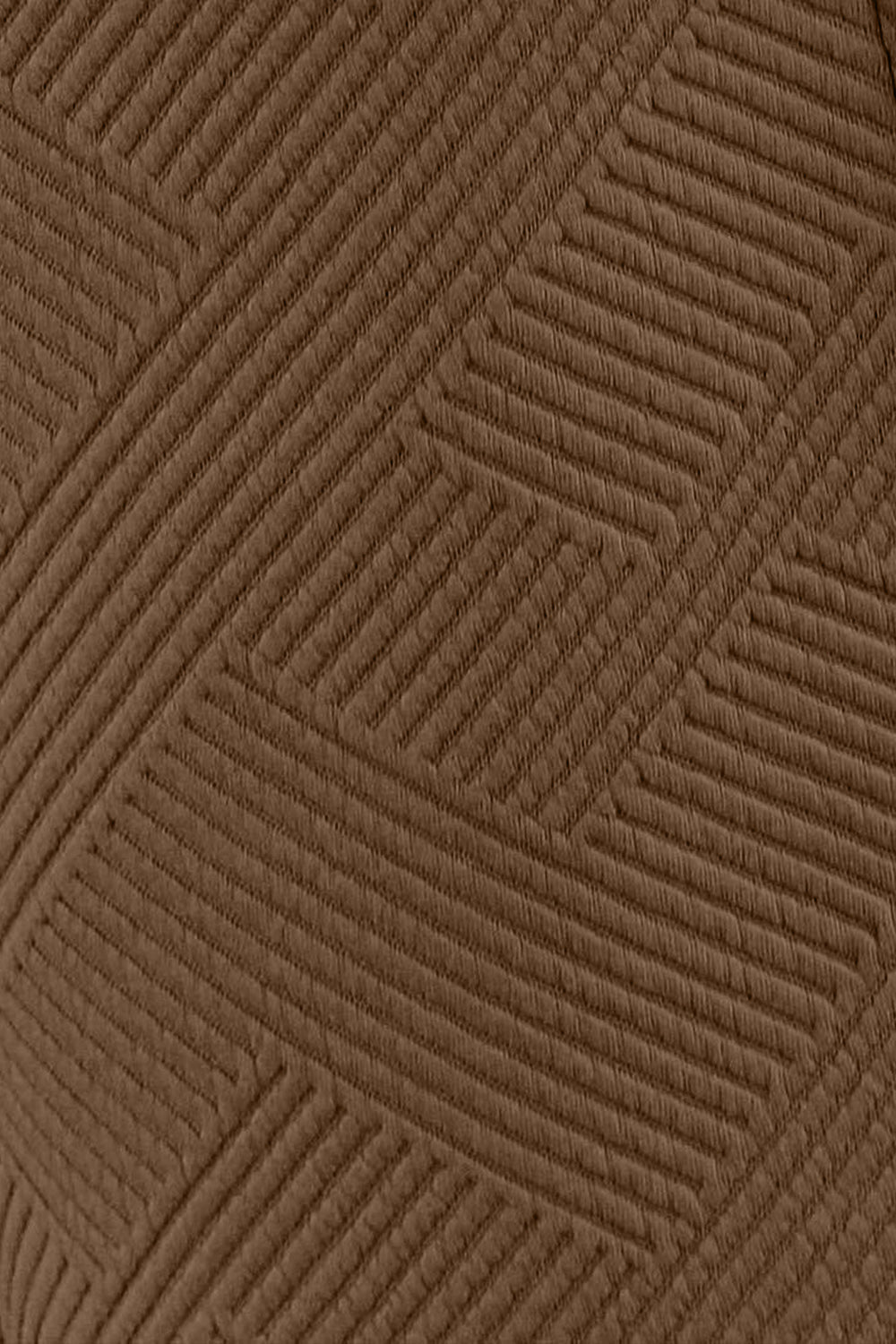 Close-up of brown textured fabric with geometric pattern from a long sleeve top and drawstring shorts set.