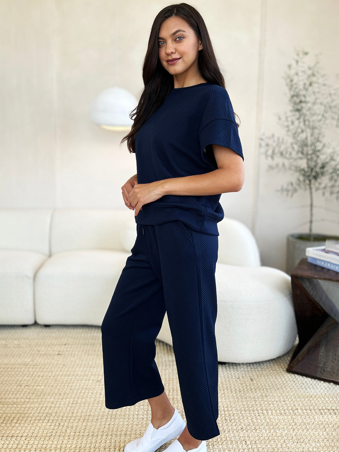 Woman wearing a navy blue texture short sleeve top and pants set with a drawstring, made from slightly stretchy polyester and spandex.