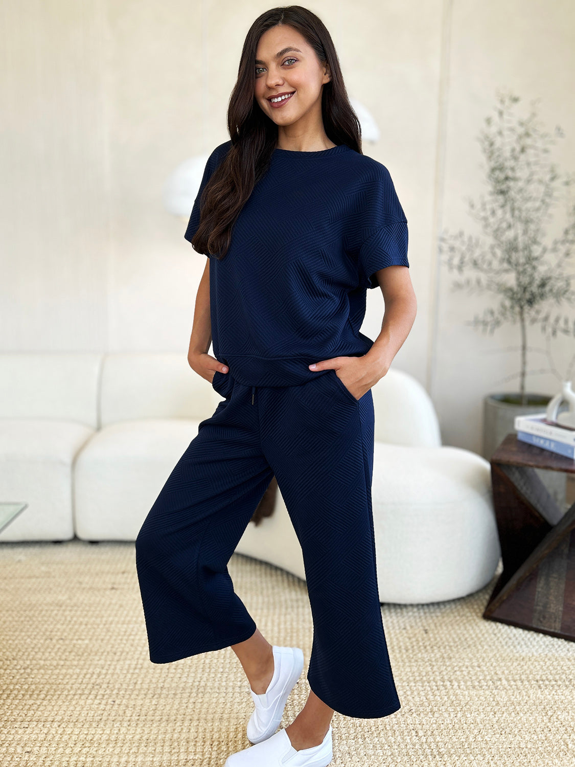 Woman wearing navy blue texture short sleeve top and pants set with drawstring, made of slightly stretchy polyester-spandex blend.