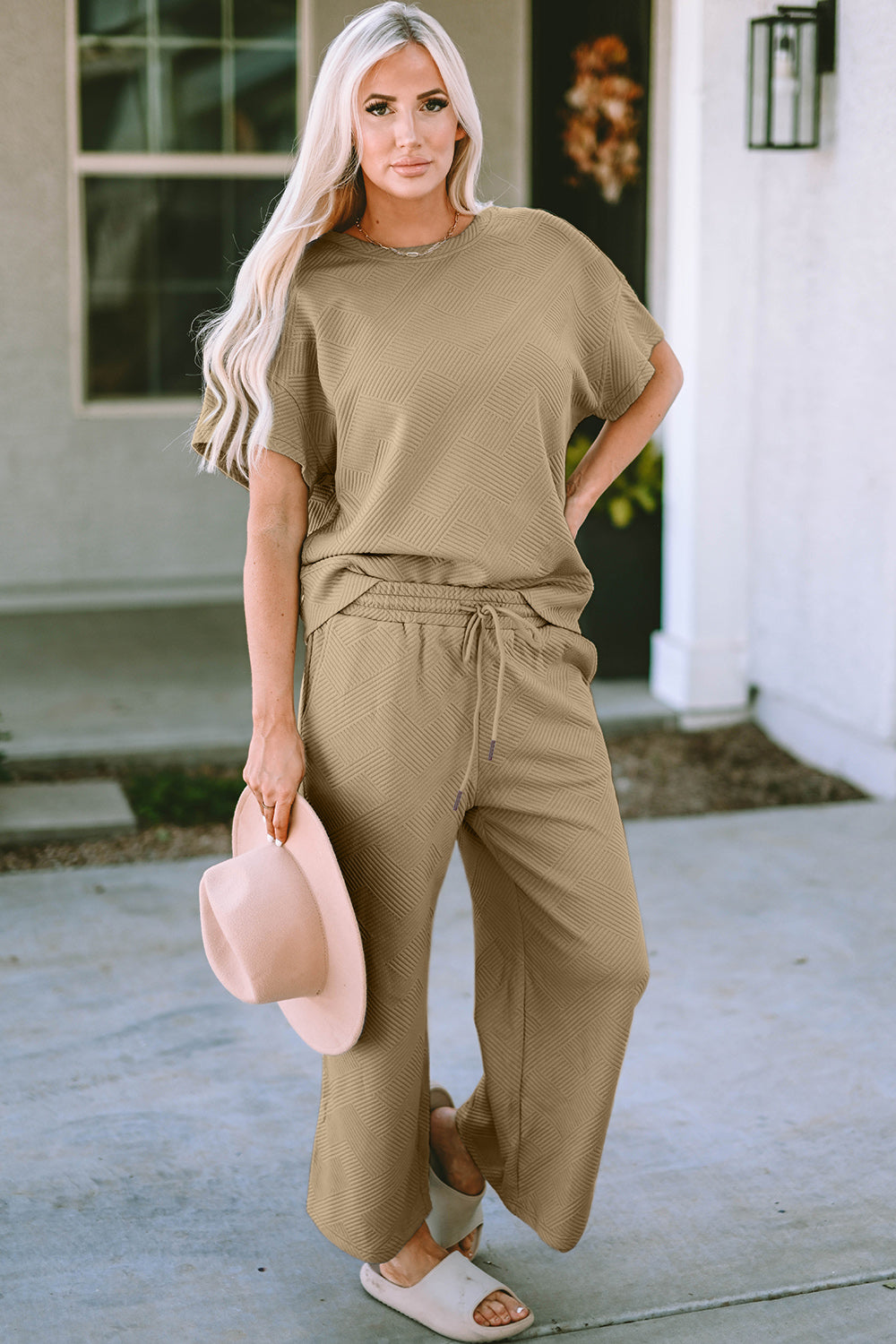 Woman wearing a texture short sleeve top and pants set with drawstring, made of slightly stretchy polyester and spandex blend.