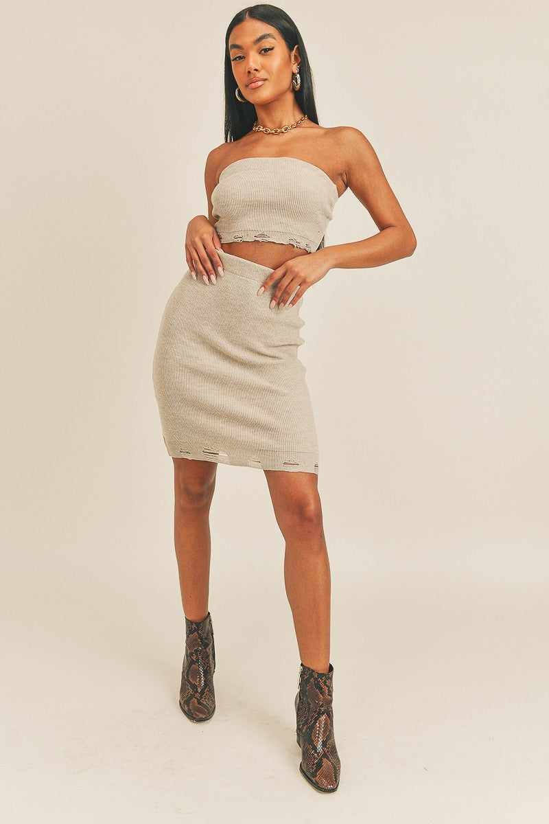 Woman wearing a crop trendy two-piece set with a tube top and high-rise pencil skirt.