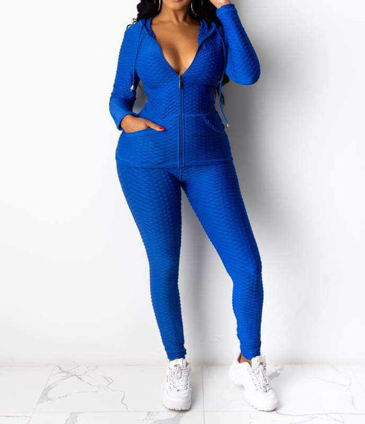 Woman wearing blue Baddie With Body Brazil Two-Piece Set with hooded jacket and pants, made of polyester and spandex.