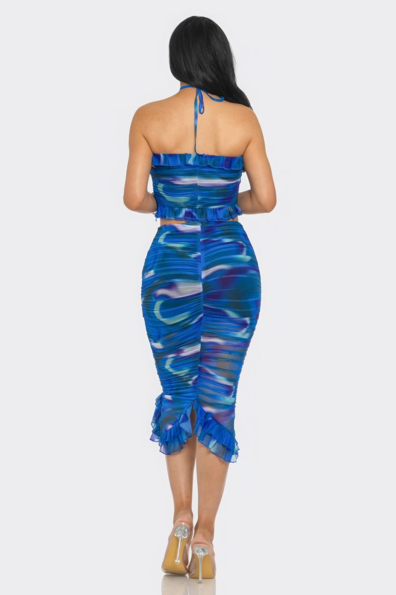 Woman wearing blue tropical print mesh ruffle halter skirt set, showcasing the back design with flirty ruffle details.