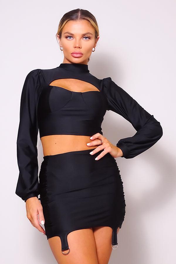 Black turtleneck blouse and side ruched mini skirt set with puff sleeves, front cutout, and garter details for a chic look.