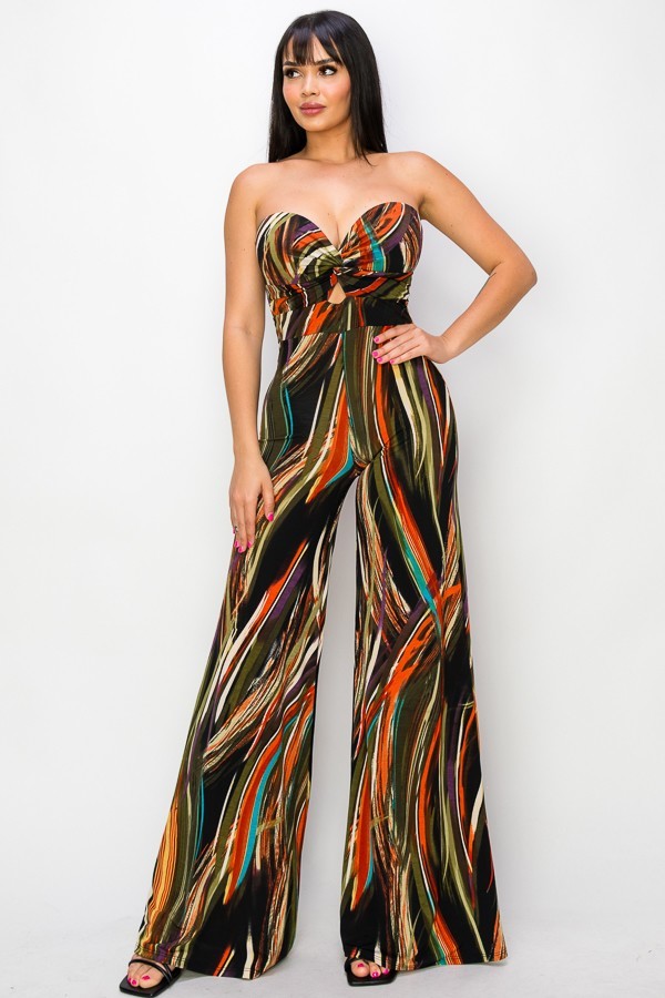 Woman wearing Twisted Love brown and green wide leg jumpsuit with strapless, marble print and twist front design.