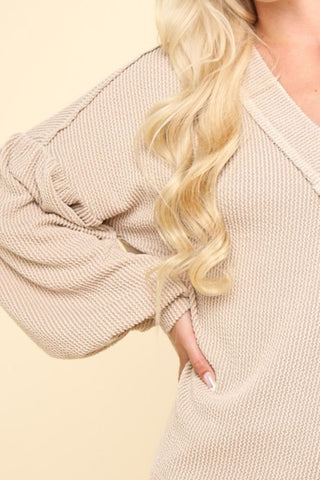 Two-tone ribbed V-neck oversized top with exposed seams and long sleeves in soft knit fabric.
