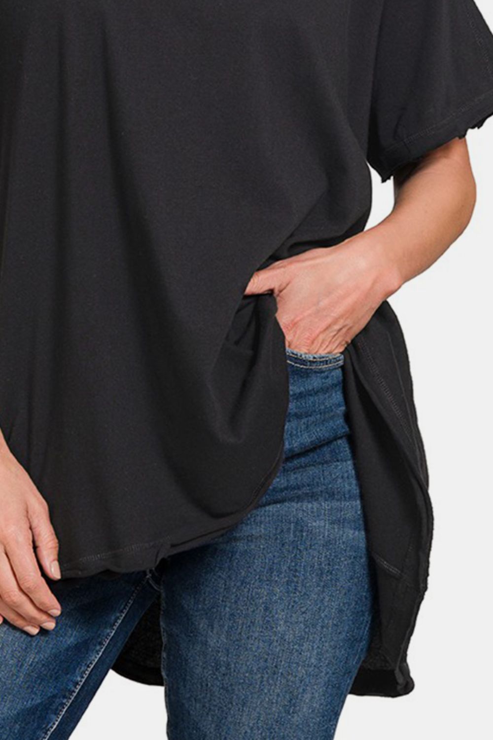 Black round neck short sleeve t-shirt with high-low hem, paired with blue jeans, made from 100% cotton, slightly stretchy fabric.