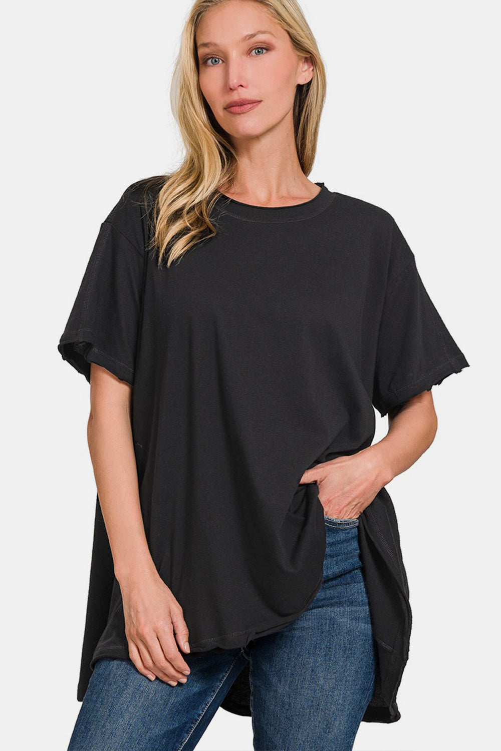 Woman wearing a black round neck short sleeve t-shirt with high-low hem and slightly stretchy, 100% cotton material.