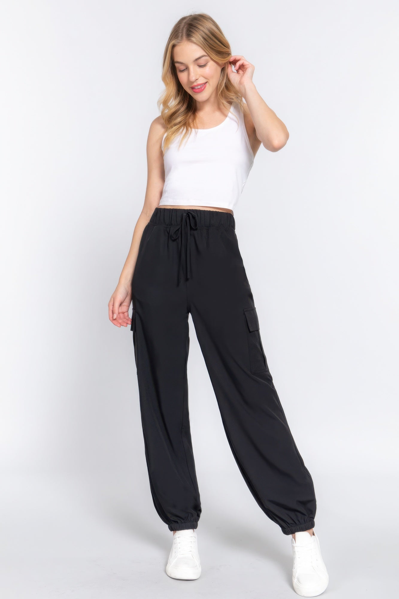 Woman wearing black lightweight stretch woven cargo jogger pants with trendy pockets, showcasing casual and stylish fashion.