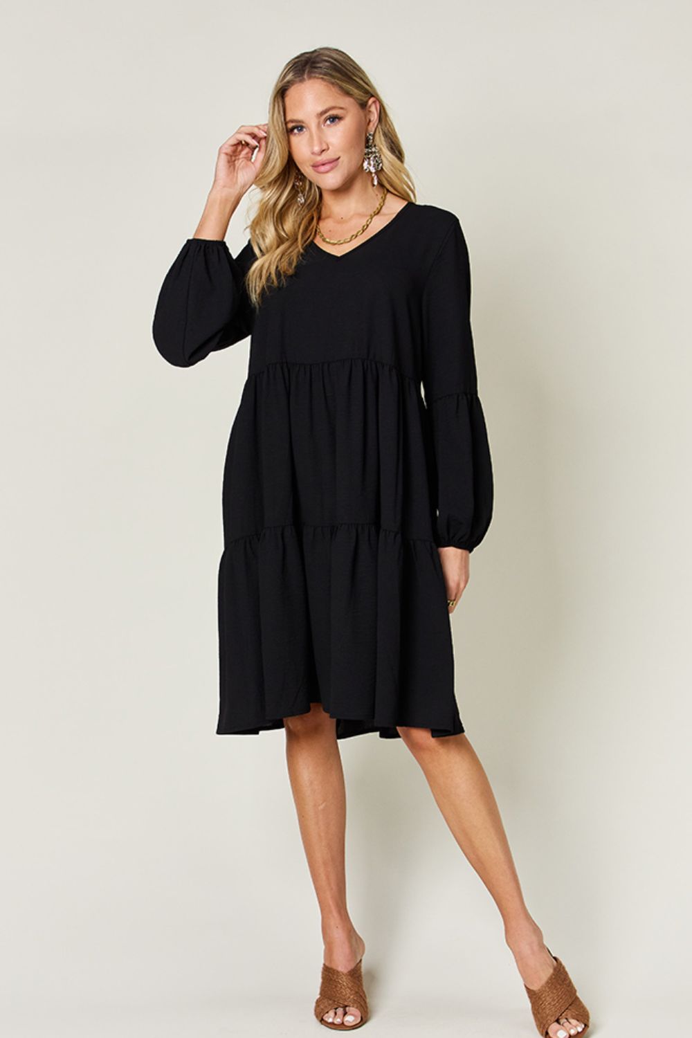 Elegant black V-neck balloon sleeve tiered dress with pockets, crafted from high stretch yarn, featuring a ruffled, flowing design.