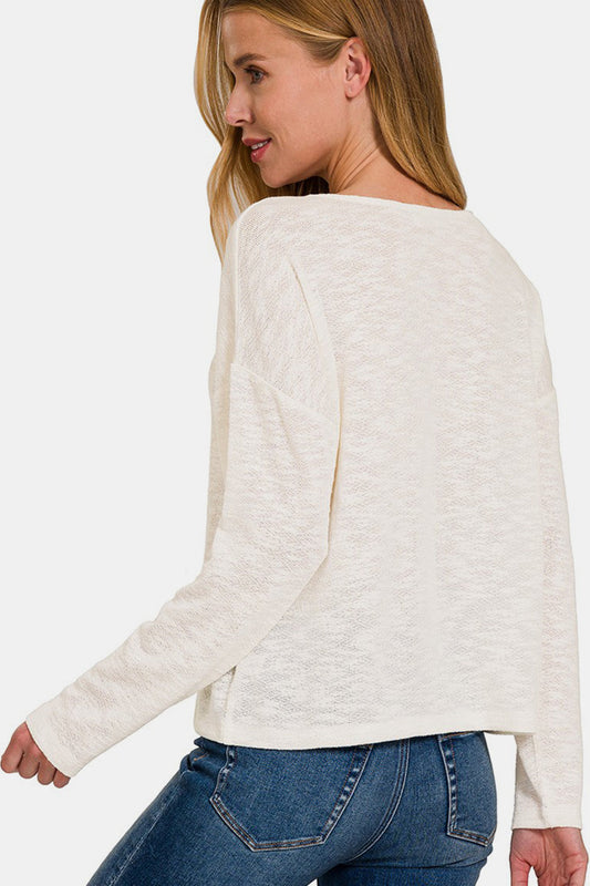 Woman wearing a V-neck dropped shoulder long sleeve T-shirt with jeans, showcasing the back design and fit in a casual style.