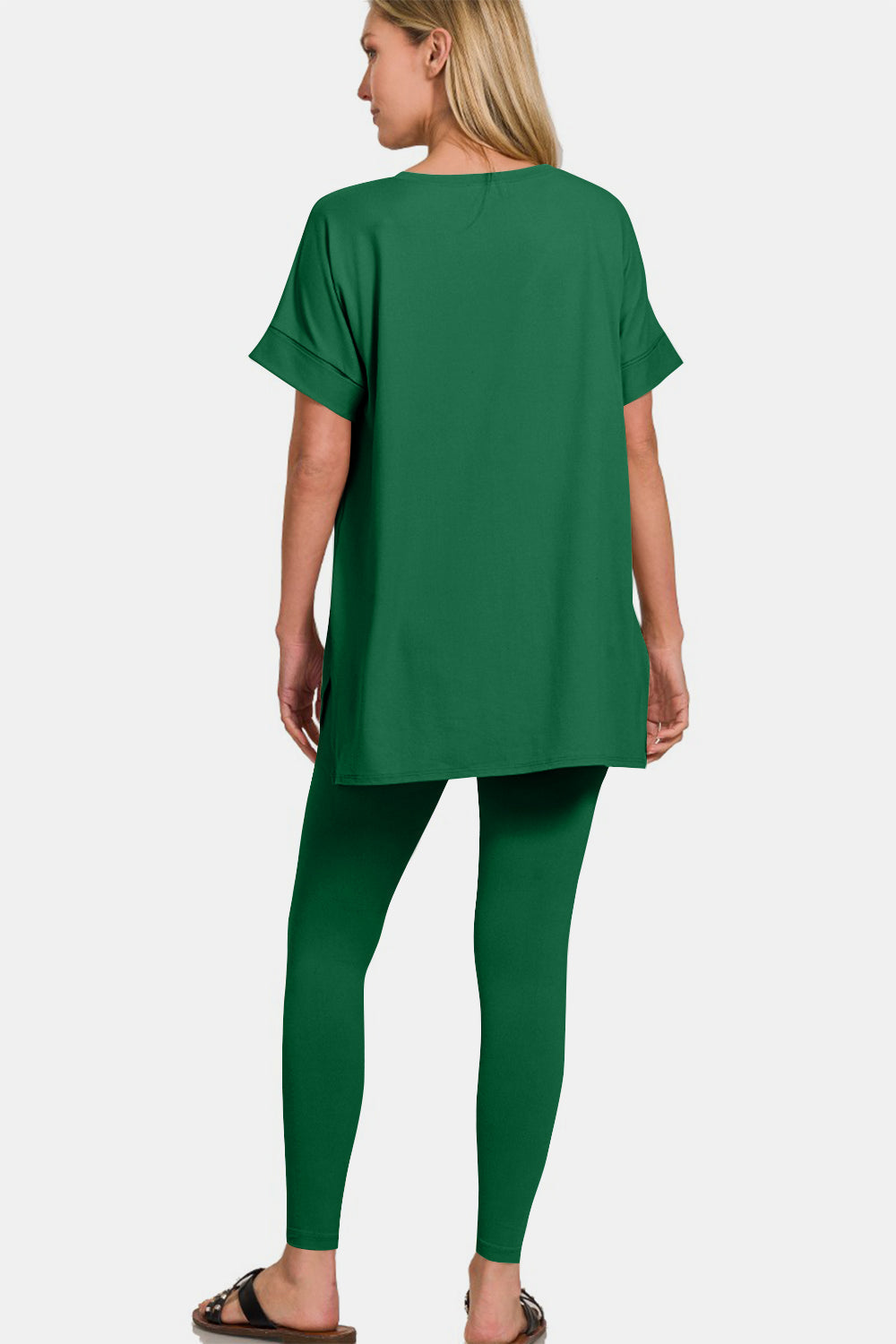 Woman wearing green V-neck rolled short sleeve t-shirt and leggings lounge set, showcasing a stylish and comfortable casual outfit.