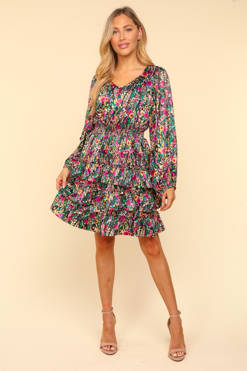 Woman wearing a V-Neck Satin Floral Layered Dress with ruffled, smocked design, made of 100% polyester.