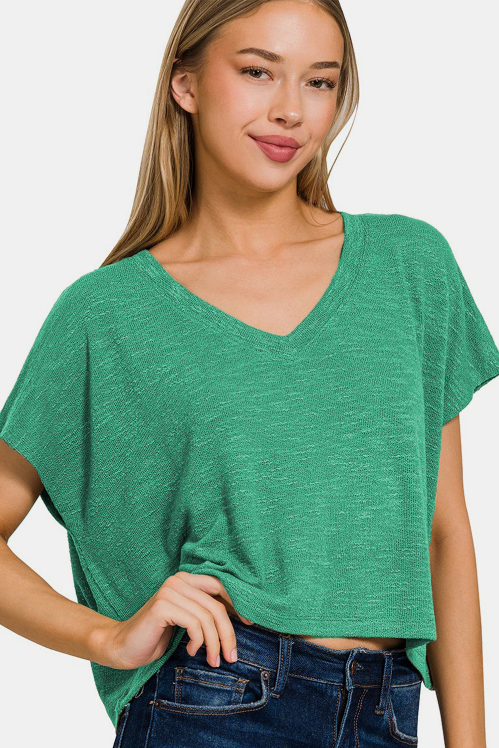 Woman wearing a green V-neck short sleeve T-shirt made of polyester, rayon, and spandex with a casual, basic style.