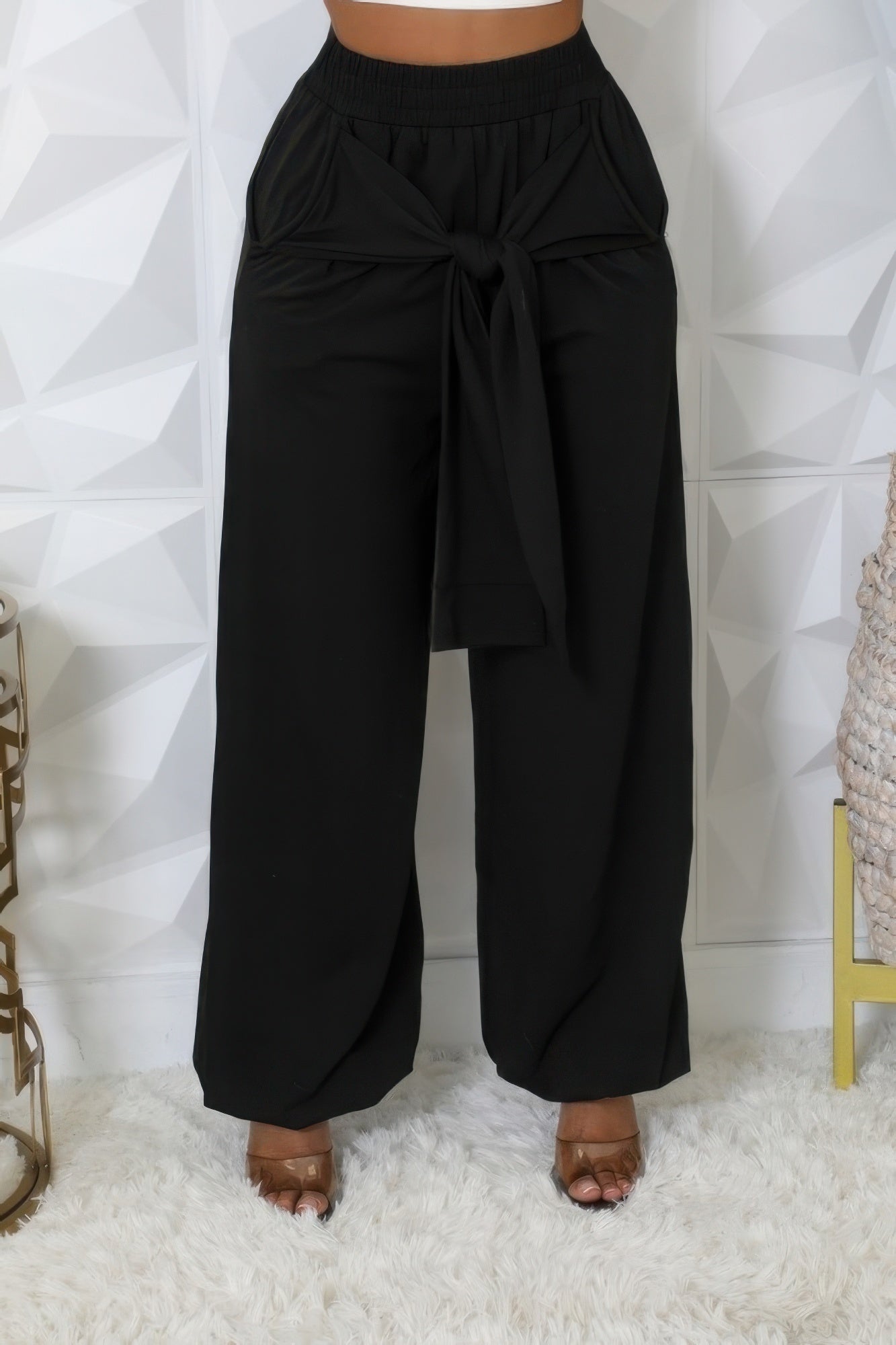 High-waisted stretch pants with tied waistband, practical pockets, and cuffed bottoms for a stylish and comfortable fit.