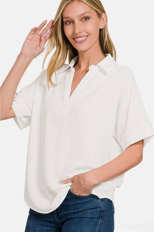 Woman wearing a white texture collared neck short sleeve top with jeans.