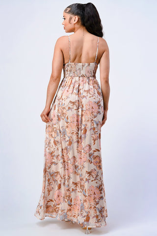 Woman wearing vintage floral smocked chiffon fit and flare maxi dress in blush, showcasing back design. Model is 5'8", size small.