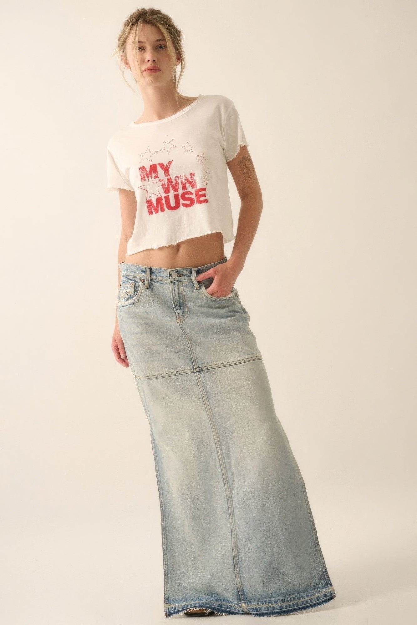 Vintage wash cropped tee with "My Own Muse" graphic and star print, styled with a long denim skirt for trendy casual look.