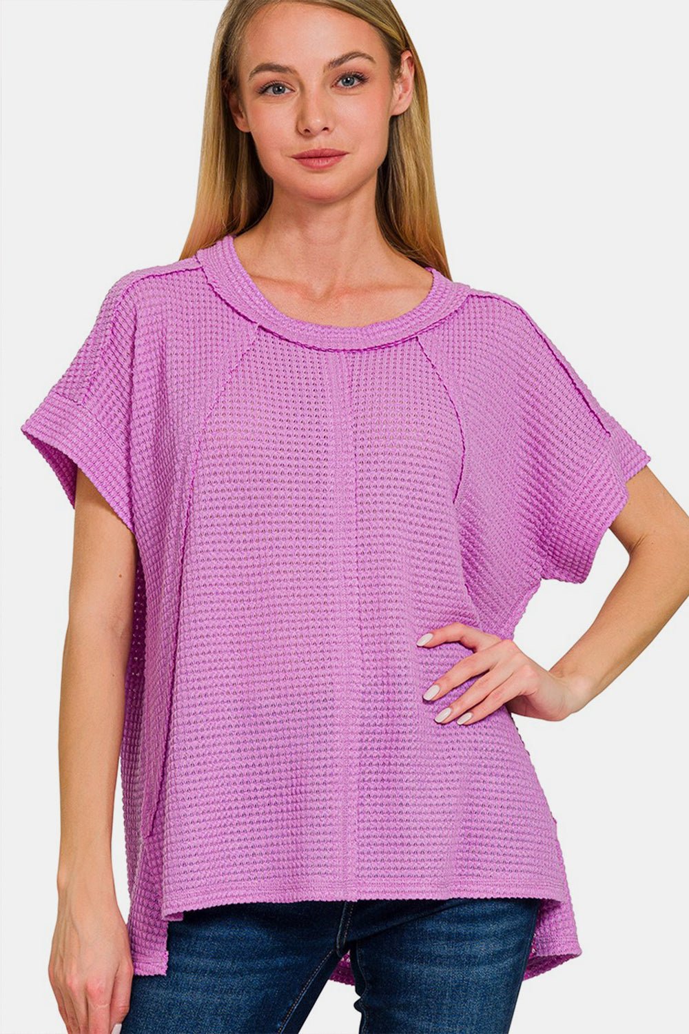 Woman wearing a pink waffle exposed-seam short sleeve t-shirt, featuring soft, slightly stretchy fabric perfect for casual wear.