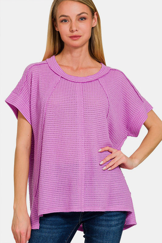 Woman wearing a pink waffle exposed-seam short sleeve t-shirt, featuring soft, slightly stretchy fabric perfect for casual wear.