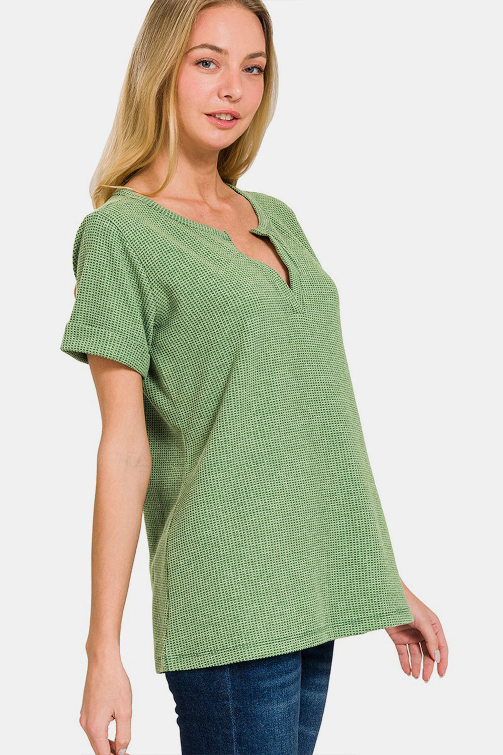 Woman wearing green waffle notched short sleeve t-shirt with slightly stretchy material, blending comfort and style.