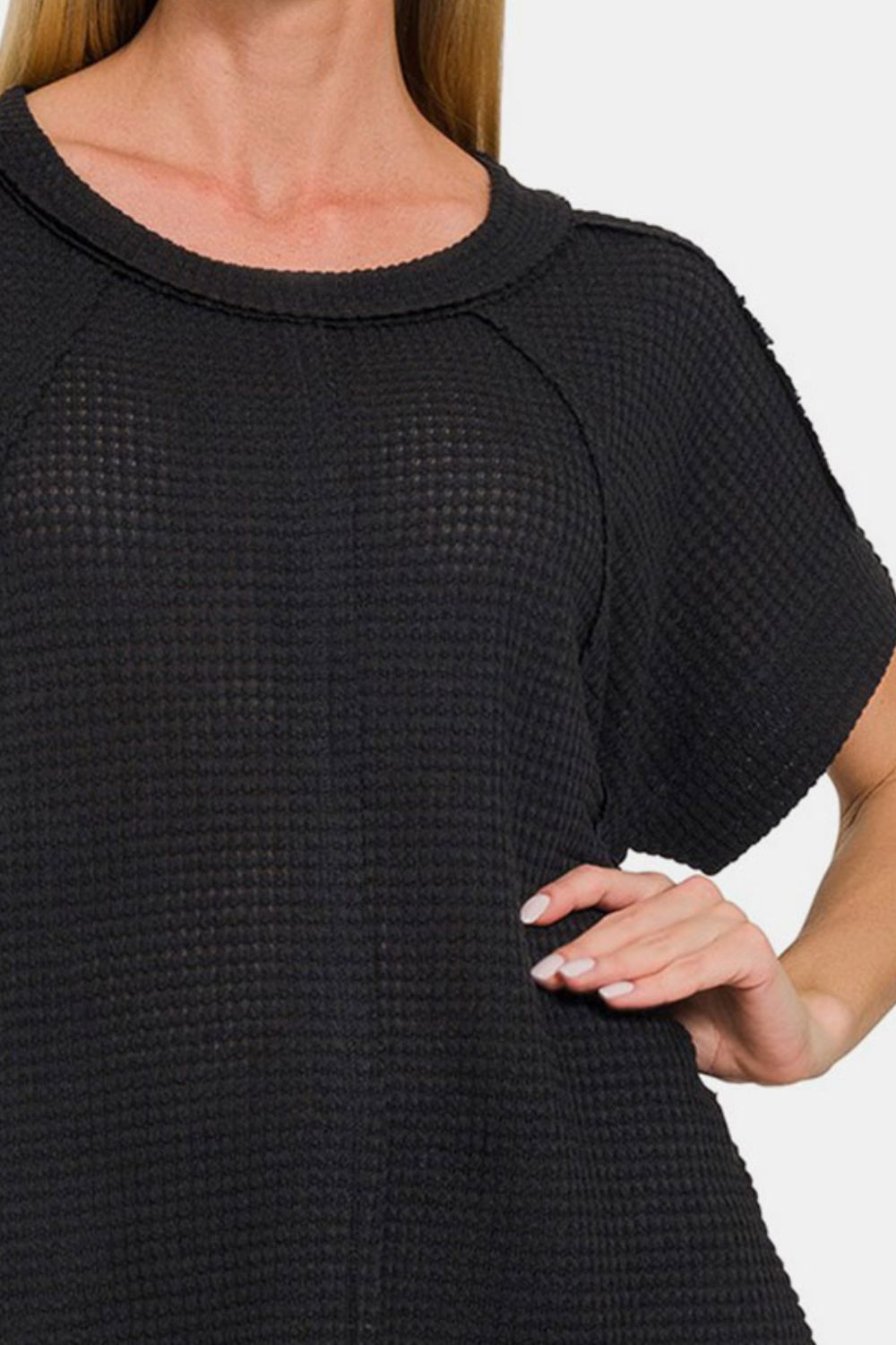 Black waffle exposed-seam short sleeve t-shirt showcasing trendy texture and edgy style, ideal for casual and layered outfits.