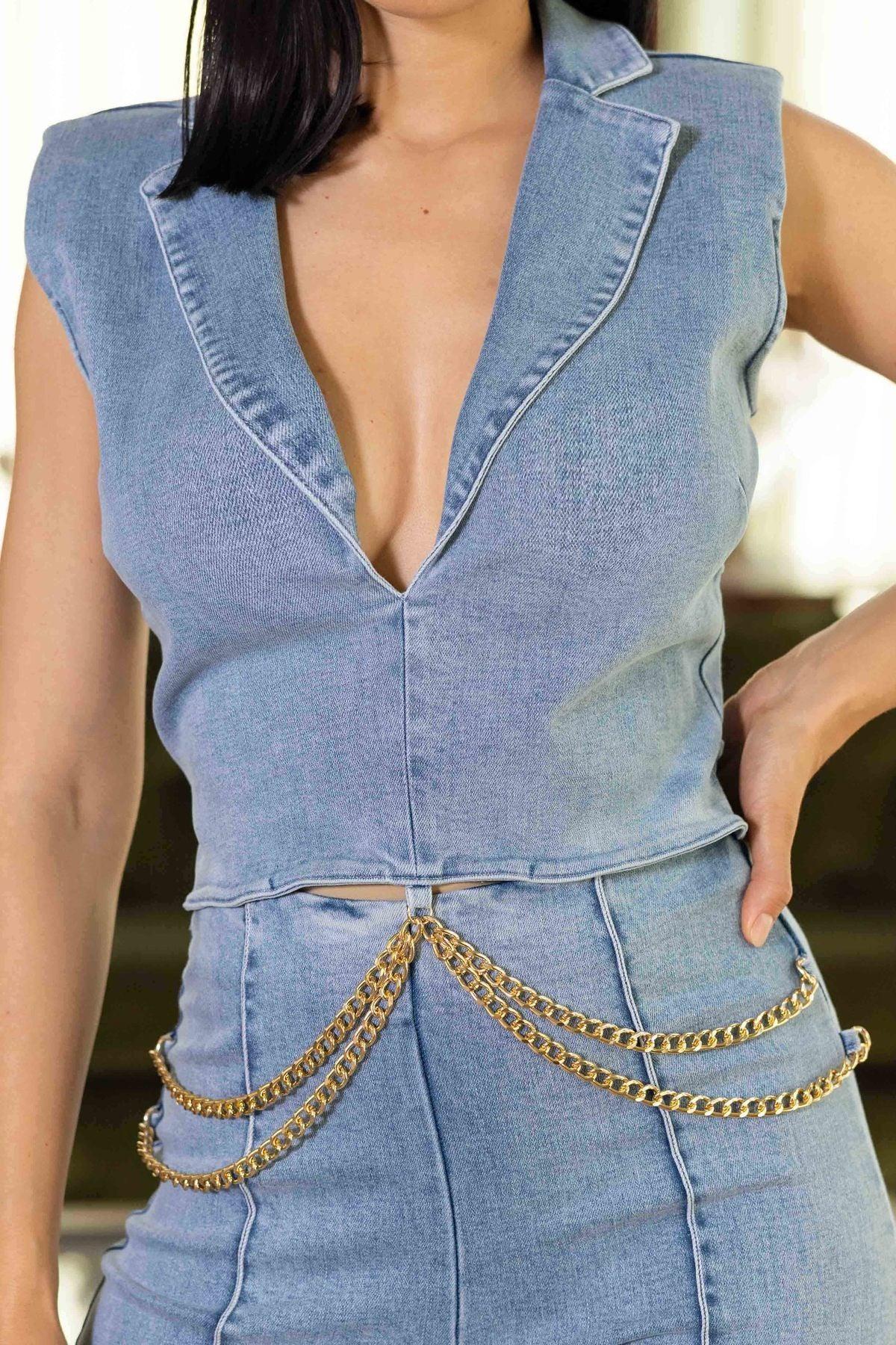 Sleeveless washed denim jumpsuit with collar and waist chain detail, featuring a back zipper for a fashion-forward look.