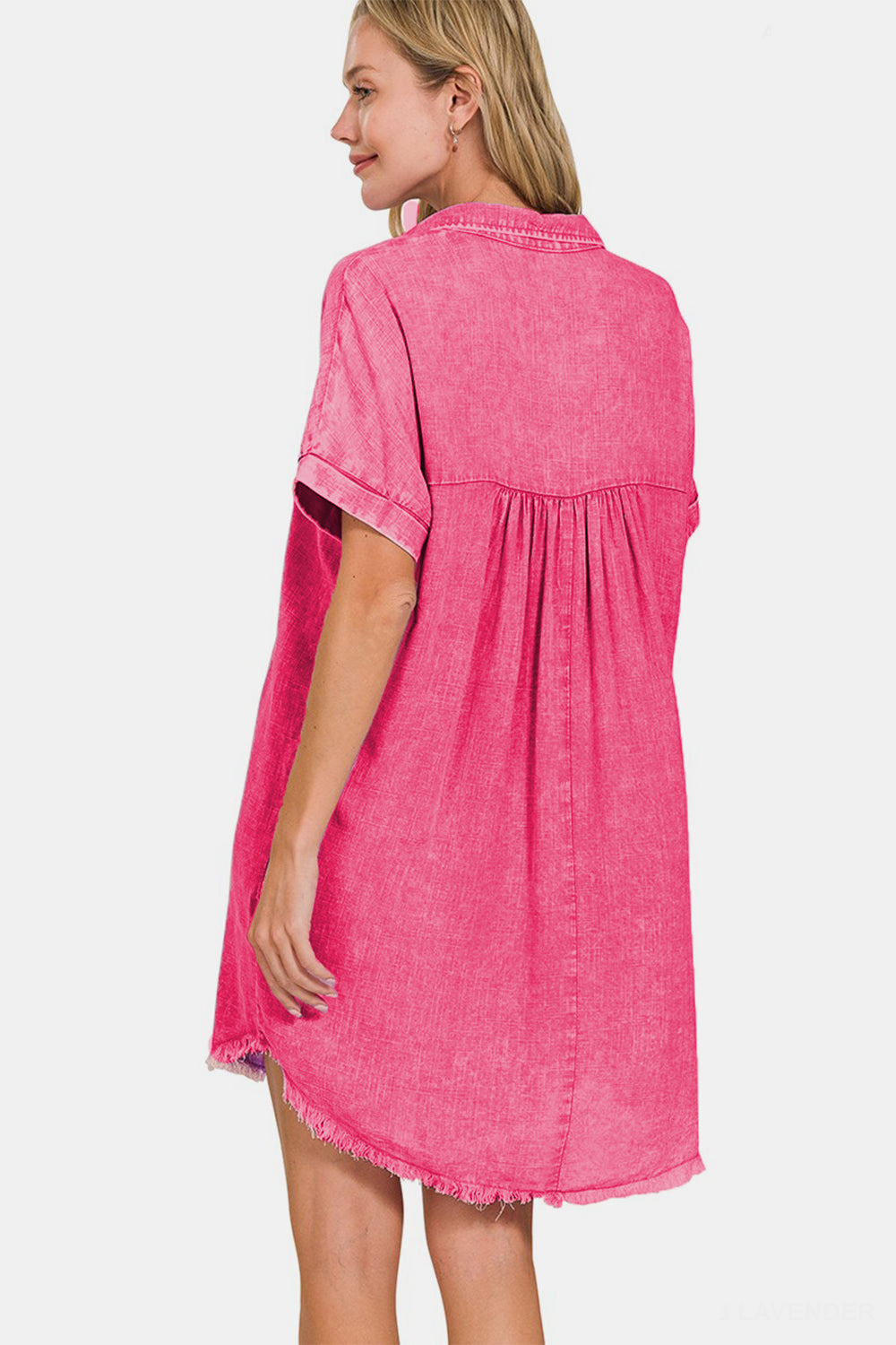 Woman wearing pink washed linen V-neck raw hem dress, rear view showing relaxed fit and moderate stretch fabric.