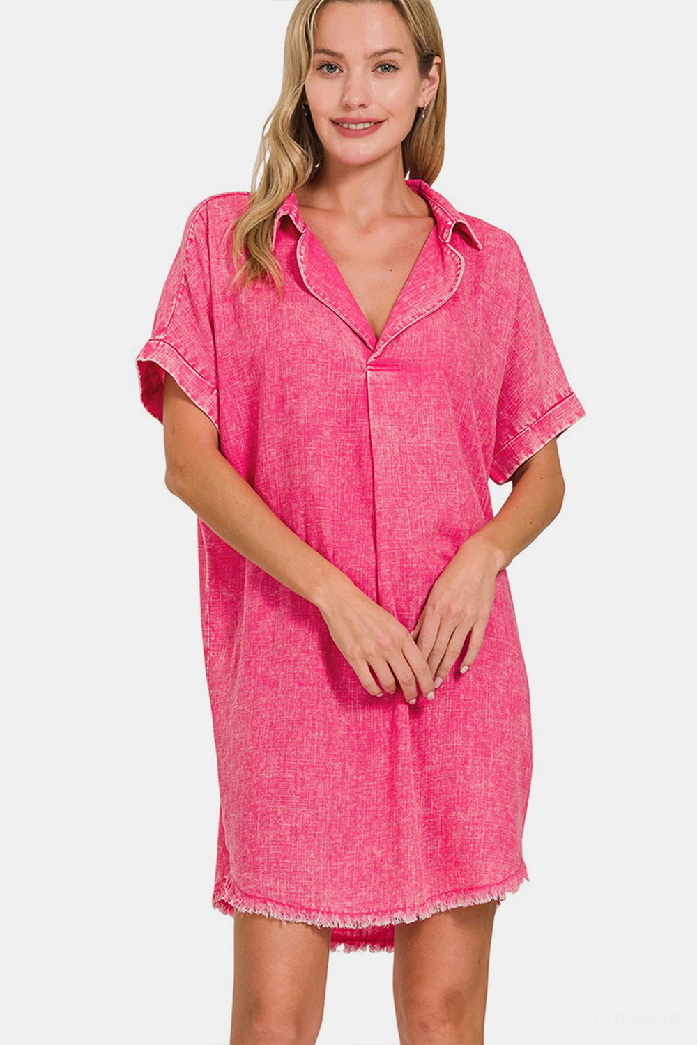 Woman wearing a pink washed linen V-neck dress with raw hem, featuring moderate stretch and basic style.