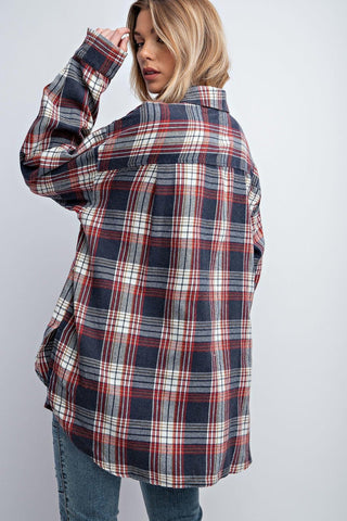 Woman wearing a washed plaid button down shirt with relaxed fit and dropped shoulders.