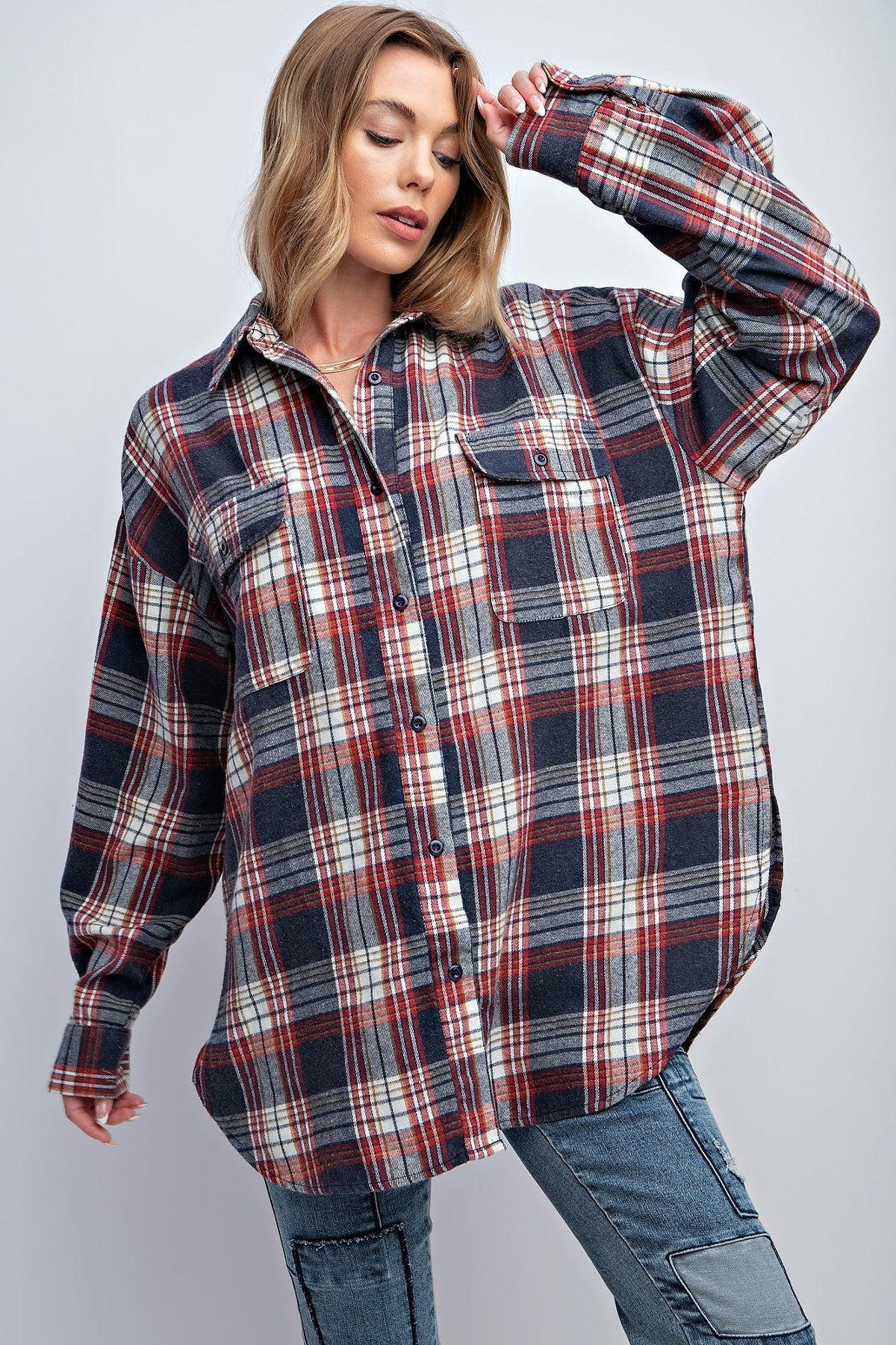 Woman wearing a relaxed fit washed plaid button-down shirt with flap pockets and rounded hem.