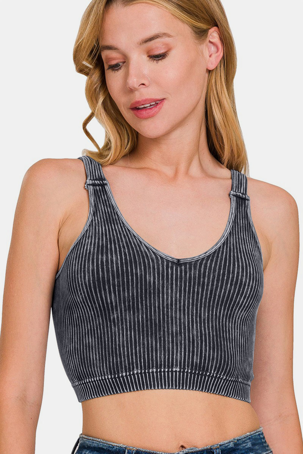 Woman wearing a washed ribbed cropped V-neck tank with moderate stretch, made of 90% nylon and 10% spandex.