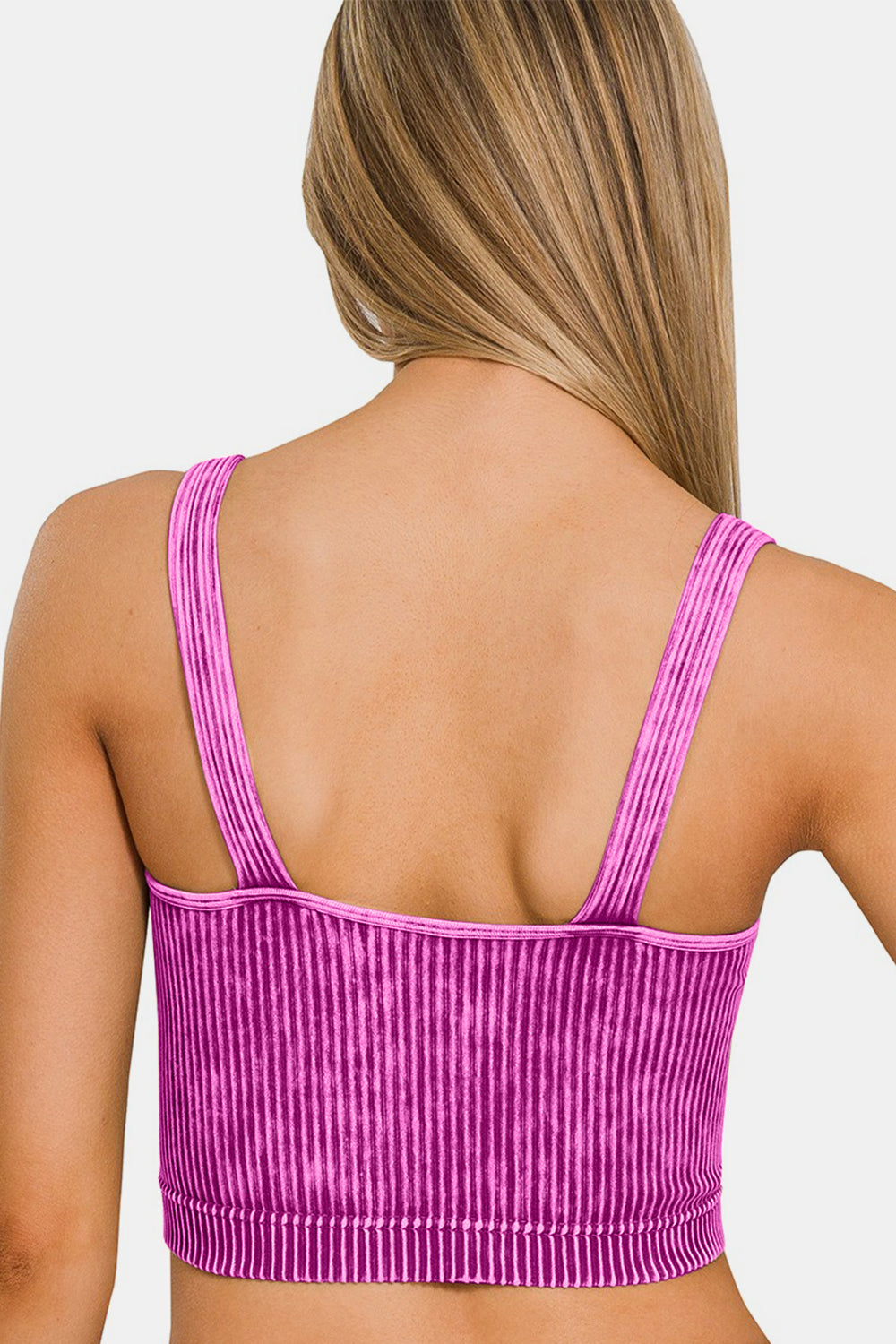 Woman wearing pink washed ribbed cropped V-neck tank top, showcasing back view and ribbed texture.