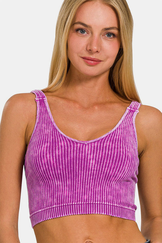 Woman wearing a pink washed ribbed cropped V-neck tank top with flattering silhouette and versatile style.